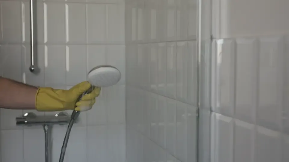 A cleaner wiping down a commercial restroom sink