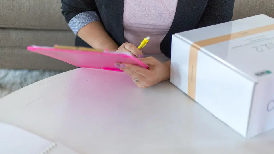 A hand holding a clipboard with a checklist