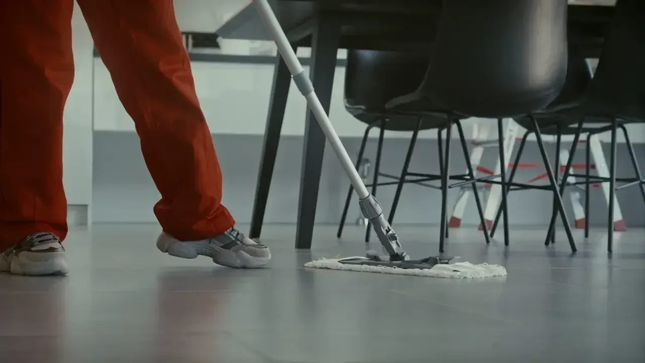 A crew member mopping a commercial hard floor